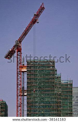tall red crane developing at the building site