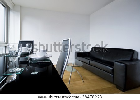a living room, lounge with a black glass top table and diner set up.