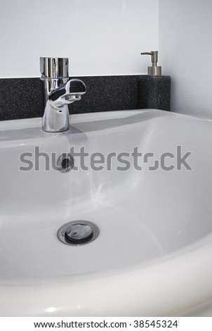 detail shot of a modern ceramic hand wash basin with chrome water mixer tap