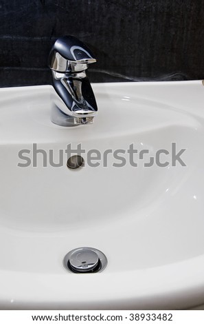 hand wash basin with a designer chrome faucet over