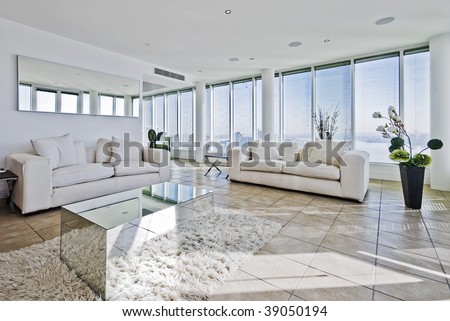 spacious penthouse living room with floor to ceiling windows and modern furniture