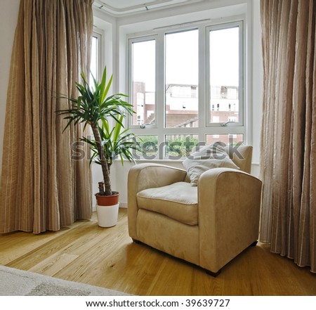 detail shot of a living room with a bay window armchair and plant