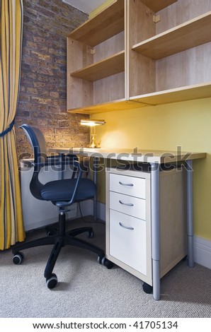 home office with chair, desk, drawers and exposed brick work