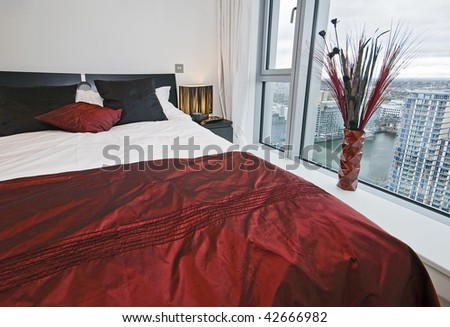 bedroom with floor to ceiling window and city views