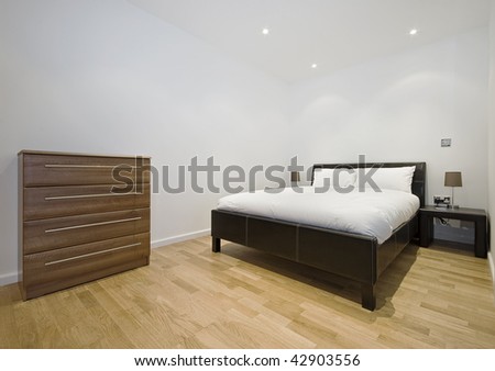 bedroom of a modern studio apartment with laminate floor throughout