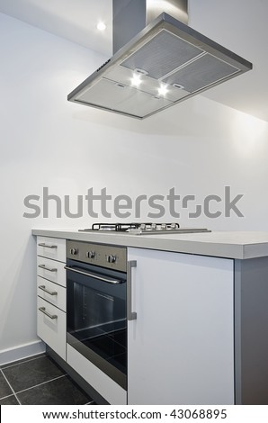 modern kitchen counter with electric oven and cooker hood