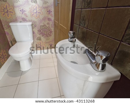 rest room with a small ceramic sink and designer wall paper with flower motif
