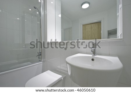 contemporary bathroom with floor to ceiling tiles and white suite