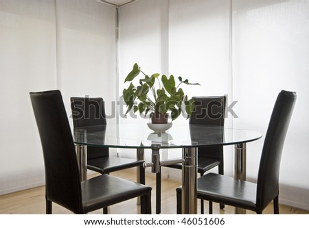 Round Glass Top Dining Table With Four Leather Chairs Stock Photo