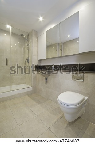 modern en-suite bathroom with shower cabin and floor to ceiling tiles