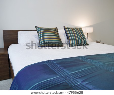 detail of a double bed with duvet and colorful bed sheet