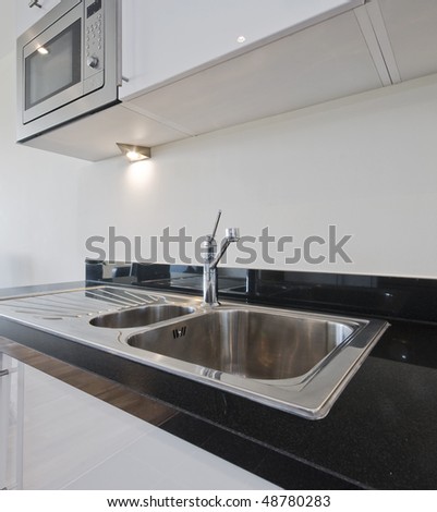 Designer Kitchen Sink on Stainless Steel Kitchen Sink On Black Granite Worktop Stock Photo
