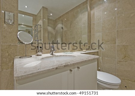 luxury modern bathroom with marble tiles and white ceramic suite