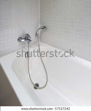 white ceramic bath tub with shower attachment and mozaic tiles