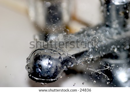 Bath tap under a leaky, dripping shower in need of repair. Shallow depth of focus.