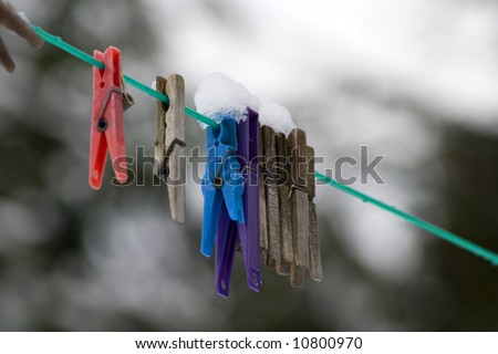 Snow covered clothes pegs on the washing line.