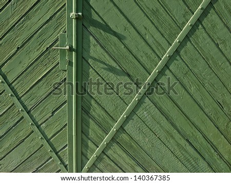 Green old wooden garage doors with metal profile