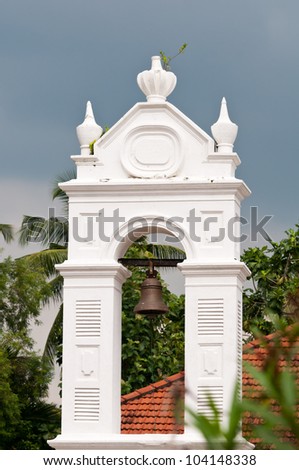 Old church bell in white arch as example of colonial architecture, Sri Lanka