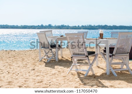 Cafe on a tropical beach with blue sea on background