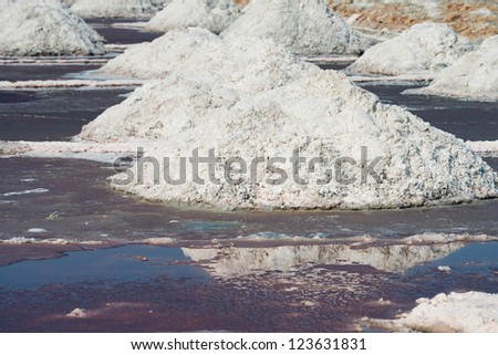 Salt piles in salt farm on Sambhar Salt Lake, India. It is India\'s largest saline lake and it produces 196 k tonnes of clean salt every year.