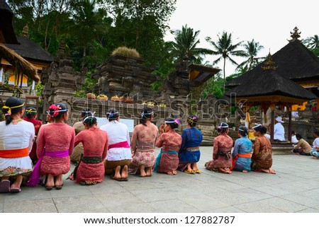 TAMPAK SIRING, BALI, INDONESIA - SEP 21: People praying at holy spring water temple Puru Tirtha Empul during the religious ceremony on Sep 21, 2012 in Tampak Siring, Bali, Indonesia
