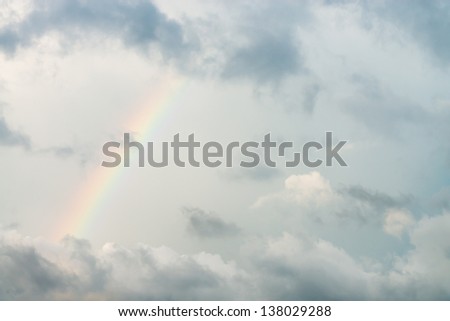 Dark cloudy sky with rainbow after rain storm