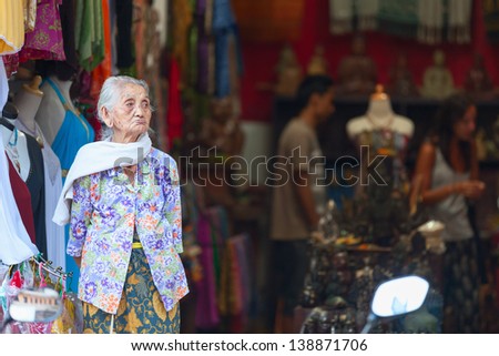UBUD, BALI, INDONESIA - SEP 19: Old woman stand in the front of souvenir shop on Sep 19, 2012 in Ubud, Bali, Indonesia. Female life expectancy at birth in the county is 74 years.