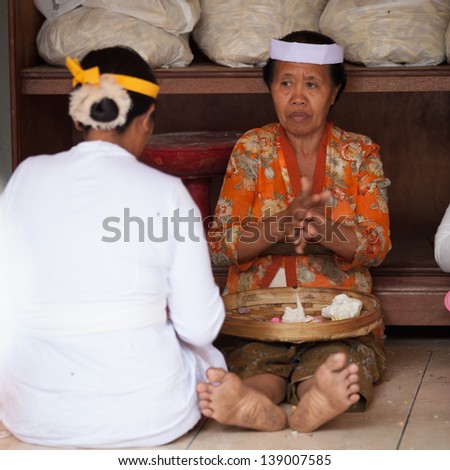 TAMPAK SIRING, BALI, INDONESIA - SEP 21: Women make sweets for balinese traditional offerings to gods in temple Puru Tirtha Empul on Sep 21, 2012 in Tampak Siring, Bali, Indonesia