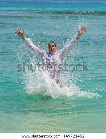 Man has fun in the blue sea by jumping up and spashing water