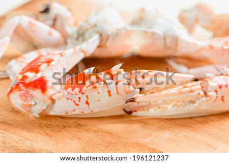 Claw of fresh boiled and dressed crabs on wooden board