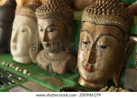 Buddha heads on a shop shelf as a Burmese souvenir. Selective focus on the first head.