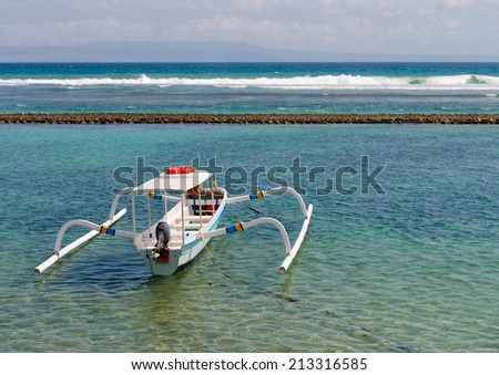 Traditional wooden fishing boats on a clean blue sea water on Bali. Indonesia.