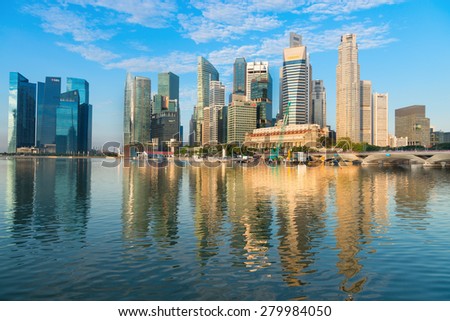 SINGAPORE - 01 JUN 2013: Stunning city skyline on a clear day, with its modern highrise towers, reflected in the calm water of the bay.