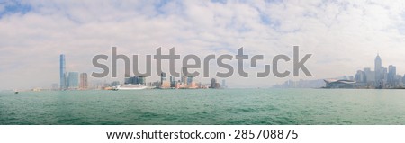 Panoramic view of the Hong Kong skyline from a boat at sea, with the International Commerce Center prominent at the far left of the frame.