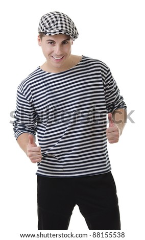 Thumbs up! by look naughty handsome young man in stylish striped dress and cap with suitcase