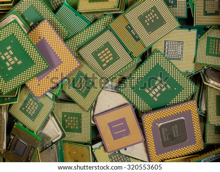 An assorted pile of CPUs. The CPUs were removed from computers for recycling. The pins on most of them are gold plated.