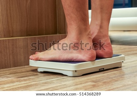 Low Section Of people Standing On Weighing Scale