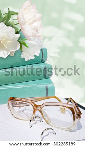 Green books, glass, white flowers on the green flower background. Education card