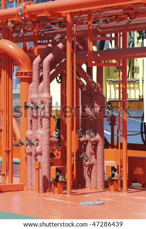 Pipes and valves in orange. Detail of industry pipelines and valves at factory