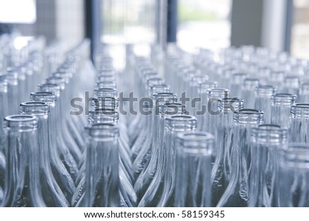 rows of empty bottles at bottling plant with swallow depth of field