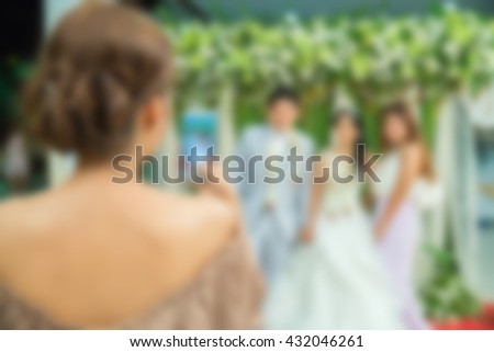 Wedding photographer taking photographs of wedding by mobile-phone , blur background