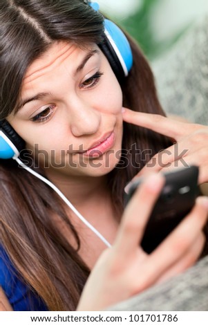 beautiful teenager girl choosing music on mobile phone