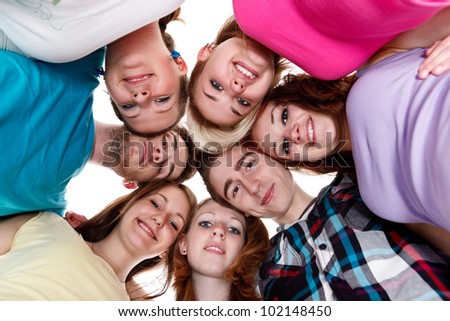 happy group of smiling friends holding heads together in circle