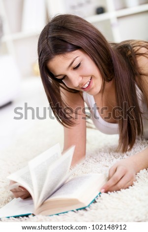 Female student lying on the floor reading a book