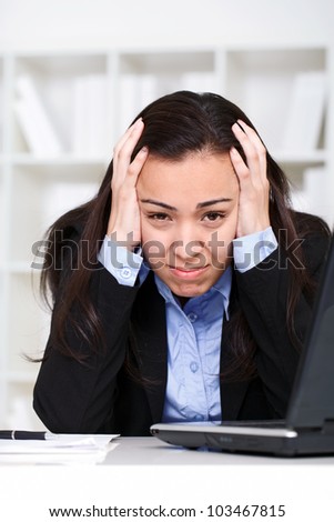 over-worked stressed businesswoman with laptop has headache