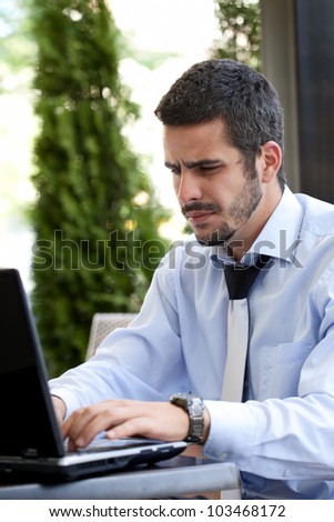 young busy businessman working on laptop on break in cafe
