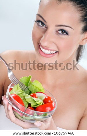 Woman eating salad,  portrait of beautiful smiling and happy woman enjoying a healthy salad