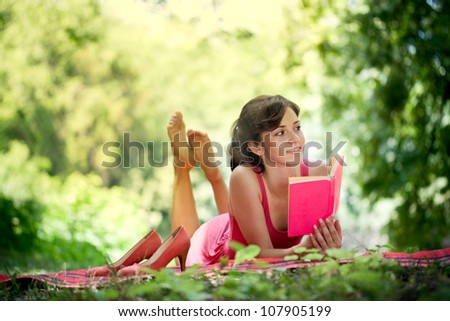 Beautiful woman with a happy face and reading in nature