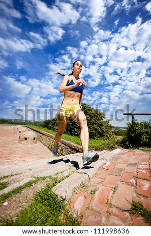 young woman jogging up steps  in nature
