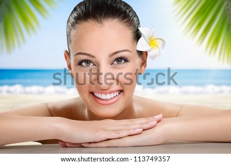 Beautiful spa woman smiling, health and beauty, against the beach